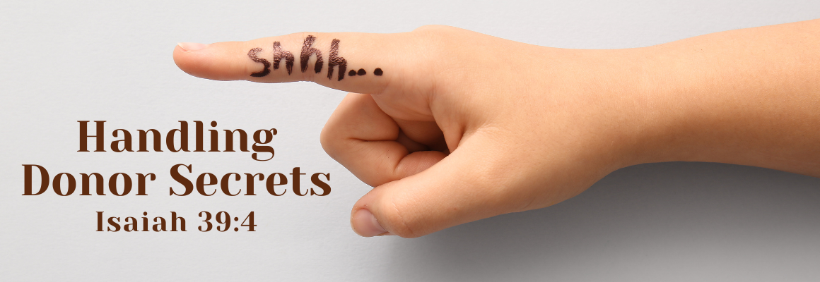 Close-up of a hand with a finger raised to the lips in a shushing gesture, with the word 'shhh...' written on the finger, next to the words 'Handling Donor Secrets – Isaiah 39:4' on a light background.
