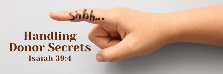 Close-up of a hand with a finger raised to the lips in a shushing gesture, with the word 'shhh...' written on the finger, next to the words 'Handling Donor Secrets – Isaiah 39:4' on a light background.