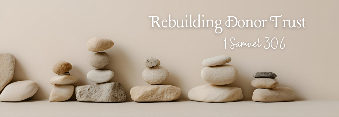 Stacked stones arranged in balanced formations on a neutral background, symbolizing stability, restoration, and rebuilding donor trust, with the title Rebuilding Donor Trust displayed above the image