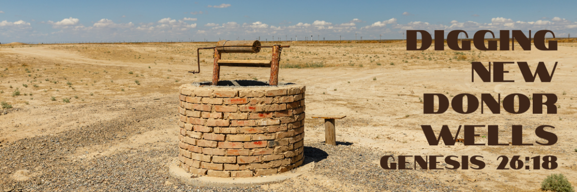An old brick well standing alone in an arid desert landscape under a blue sky, with the text Digging New Donor Wells and the scripture reference Genesis 26:18 in bold brown lettering.