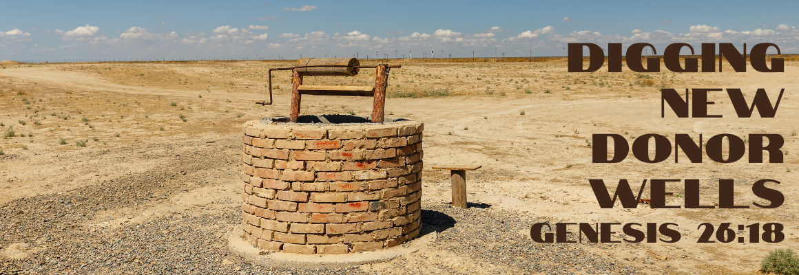 An old brick well standing alone in an arid desert landscape under a blue sky, with the text Digging New Donor Wells and the scripture reference Genesis 26:18 in bold brown lettering.
