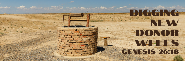An old brick well standing alone in an arid desert landscape under a blue sky, with the text Digging New Donor Wells and the scripture reference Genesis 26:18 in bold brown lettering.