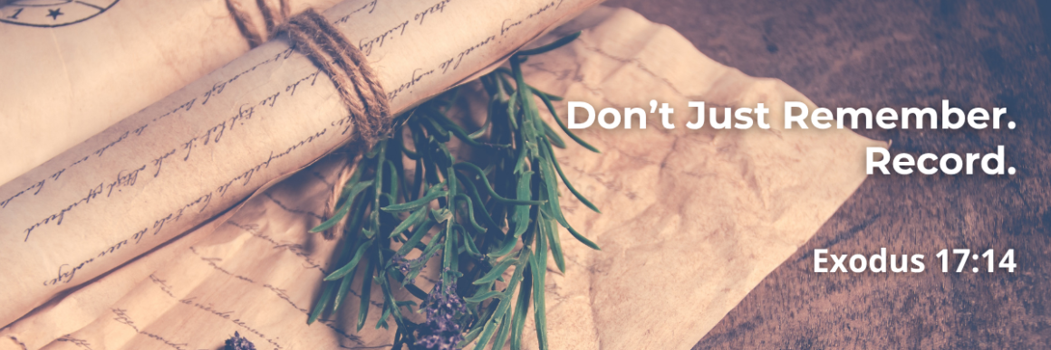 Scroll tied with twine beside rosemary and lavender, with text 'Don't Just Remember. Record. Exodus 17:14'